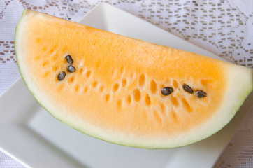 Yellow watermelon on white plate.