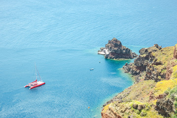 View of the sea and a catamaran from steep coast