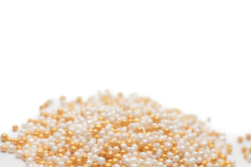 white and gold color sugar eatable pearls isolated on white background.selective focus