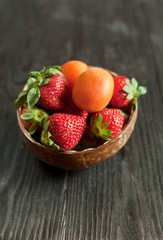 apricots and strawberry on a wooden table