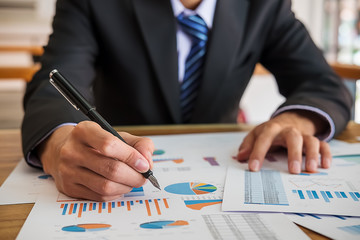 Business man working with new startup project.Hand woman holding pen pointing on summary report chart and calculate finance.discussion and analysis data the charts and graphs.