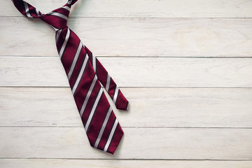 Happy Father's Day inscription with colorful tie and watch on wooden background floor background.