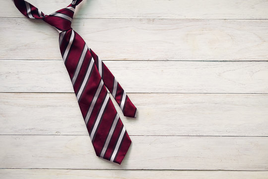 Happy Father's Day inscription with colorful tie and watch on wooden background floor background.