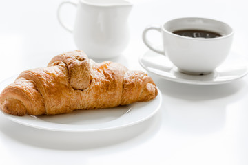 croissant and cup of coffee on office desk for business breakfast white background