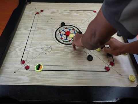 A game of carrom with pieces carrom man on the board carrom
