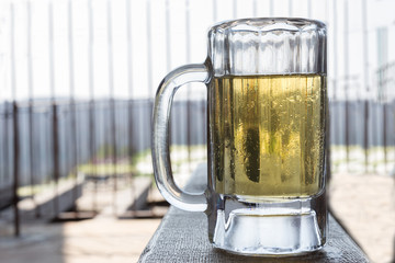 horizontal image of a beer mug full of cold beer.