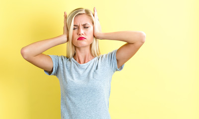 Young woman blocking her ears