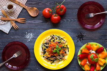 Delicious pasta with fresh vegetables and cheese, on a wooden background .