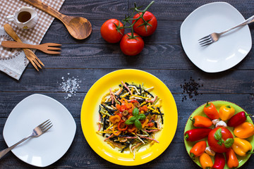 Delicious pasta with fresh vegetables and cheese, on a wooden background .