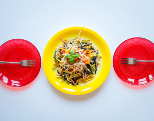 Delicious pasta with fresh vegetables and cheese, on a wooden background .
