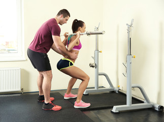 Fototapeta premium Beautiful sportive woman training with her trainer in gym