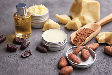 Beautiful composition with cocoa butter lotion and ingredients on table