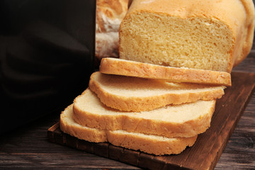Loaf baked in bread machine on wooden table