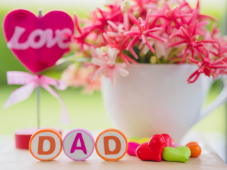 Father's day concept.  LOVE DAD alphabet with colorful heart and flower on background