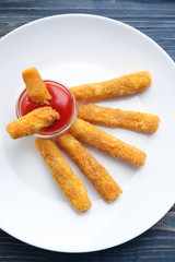 Delicious fried cheese sticks on white plate