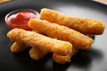 Delicious fried cheese sticks on dark plate