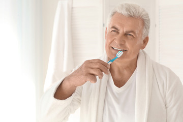 Senior man cleaning teeth at home