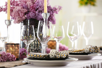 Beautiful table setting with glasses and lilac