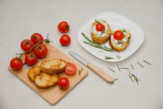 Italian bruschetta with soft cheese, tomatoes, rosemary and fresh salad on the plate. Space for text