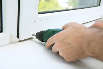Man installing window shades at home