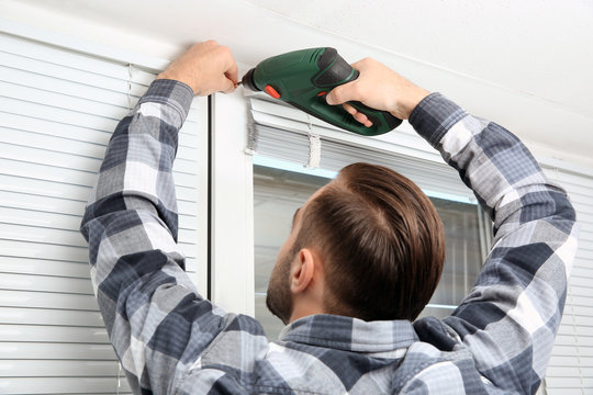 Man Installing Window Shades At Home