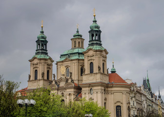 Fototapeta na wymiar The Church of St. Nicholas behind the trees in Prague