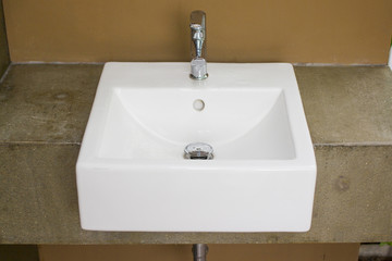 White washbasin with color earth tone of cement