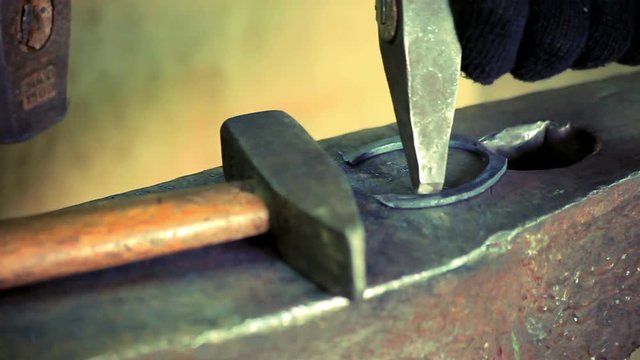 Iron horse horseshoe lie on anvil. Blacksmith making horseshoe for horse on anvil. Close up traditional metal horseshoe on anvil blacksmith. Horseshoe for horse on anvil