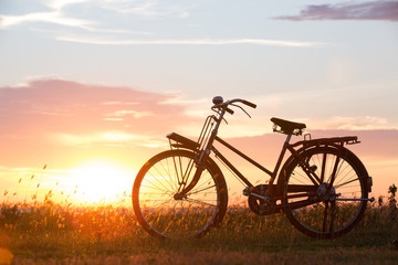 Fototapeta na wymiar bicycle with sunset or sunrise background