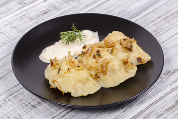 Ukrainian and Russian dish vareniki with potatoes and fried onions and sour cream.