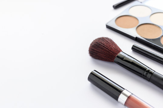 makeup cosmetics on white table with over light and soft-focus in the background