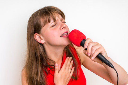 Young woman singing with red microphone