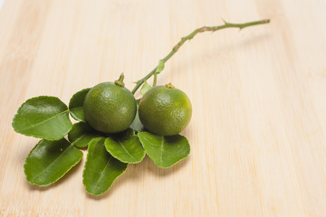 Lime fruit with leaf on wooden background