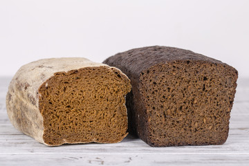 Sliced black bread on white wooden background