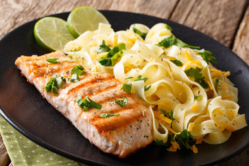 Salmon grilled with fettuccine pasta and cheese close-up. horizontal