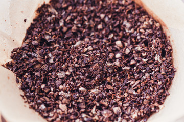 Top view of coffee beans on Coffee grinder tray, wood background