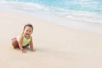 Fototapeta na wymiar Cute baby playing on a beautiful sandy beach
