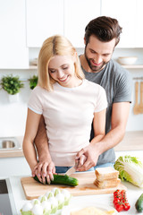 Portrait of happy young couple cooking together in the kitchen