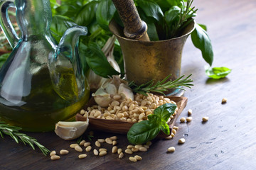 Ingredients for making pesto on a wooden table .