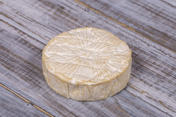 Brie type of cheese. Camembert cheese. Fresh Brie cheese on a wooden board. Italian, French cheese.