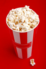 Popcorn in red and white cardboard box. Popcorn border isolated on white. Film. Fast food. Corn