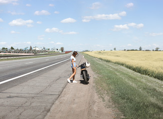 Obraz premium Biker girl stands on the road