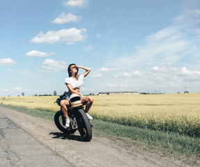 Naklejka na ściany i meble Biker girl sitting on motorcycle