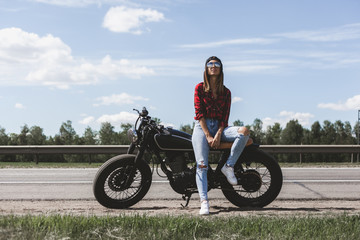Obraz na płótnie Canvas Biker girl sitting on motorcycle