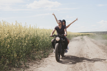 Obraz premium couple in field on motorcycle