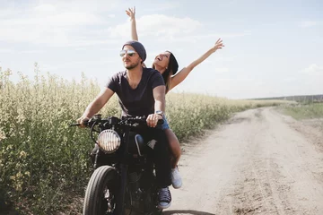 Fotobehang couple in field on motorcycle © Kaponia Aliaksei