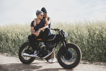 Obraz na płótnie Canvas couple in field on motorcycle