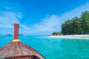 Long tail boat against blue sky and sea. Koh Lipe island, Satun, Thailand..Beautiful view from a bow of yacht at seaward.Copy space.Traditional wooden boat in a picture perfect tropical bay