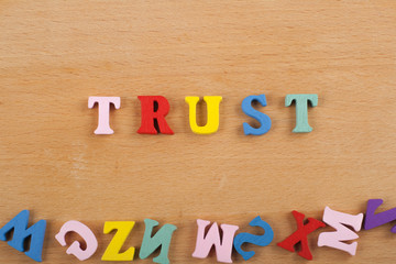 TRUST word on wooden background composed from colorful abc alphabet block wooden letters, copy space for ad text. Learning english concept.