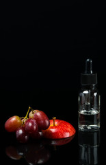 Grapes flavor with a red apple in a glass vial on a black background